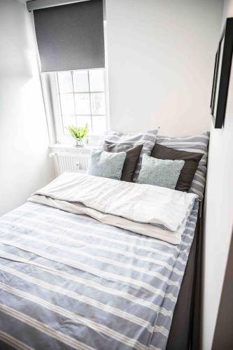 a bed with blue and white sheets and a window at FeWo Waldblick in Meschede