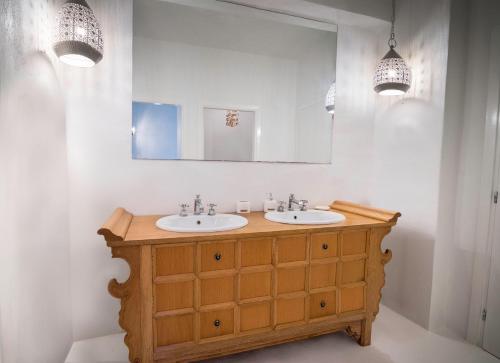 a bathroom with two sinks and a mirror at Villa Arios, pool, jacuzzi and sea in Kanapitsa