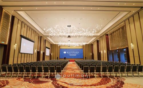 a large room with chairs and a stage in it at Pullman Huizhou Kaisa in Huizhou