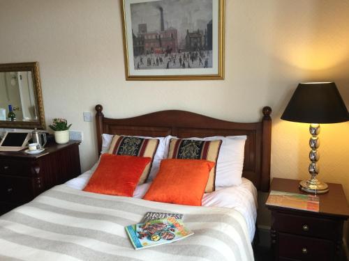 a bedroom with a bed with orange pillows at Taunton Town House in Taunton