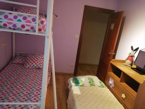 a bedroom with a bunk bed and a desk at Alojamiento Quintanilla in Gijón