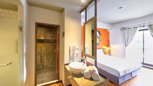 a bedroom with a bed and a bathroom with a shower at Cacha Hotel in Bangkok