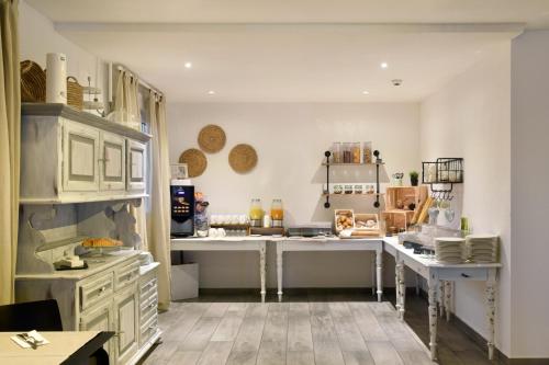 a kitchen with white cabinets and a counter top at Hôtel des Mosaiques in Orbe