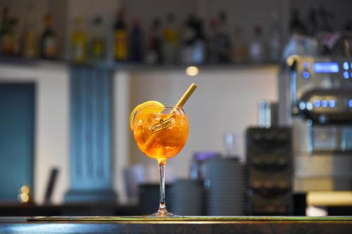 a drink with a stick in a glass on a counter at Hôtel des Mosaiques in Orbe