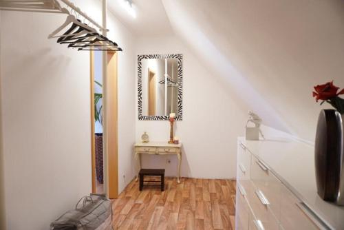 ein weißes Zimmer mit einem Spiegel und einem Tisch in der Unterkunft FeWo LaChristina Köln-Bonn-Siegburg in Troisdorf