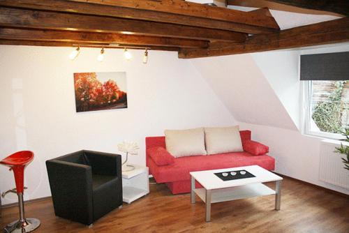 a living room with a red couch and a tv at Hermann's Neue Post in Calw