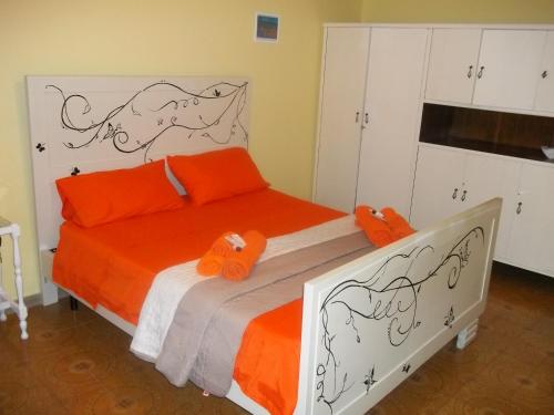 1 dormitorio con 1 cama con almohadas de color naranja en Welcome to the "Rossinelli Lodge", en Montauro