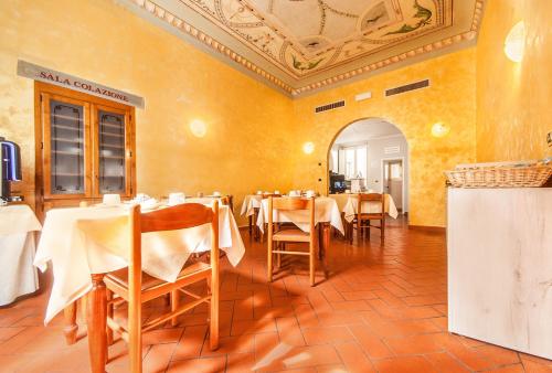 um restaurante com mesas e cadeiras num quarto em Hotel Costantini em Florença