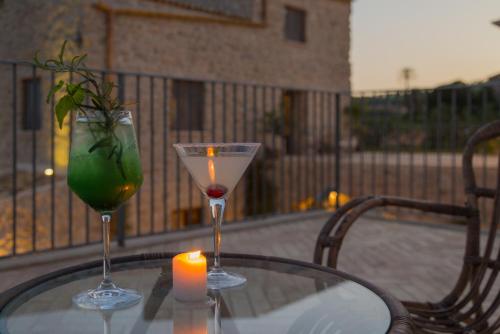 a table with two glasses and a candle on a balcony at Masseria Agnello in Realmonte