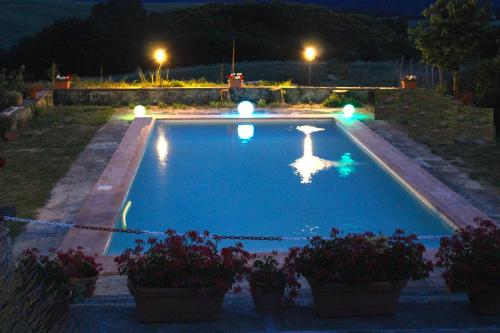 una piscina por la noche con macetas y luces en Villa Medicea Lo Sprocco, en Scarperia