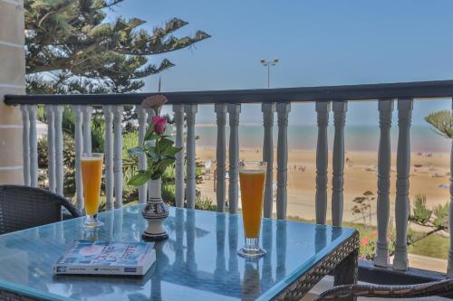 a table on a balcony with two glasses of beer at Hôtel Des Iles in Essaouira