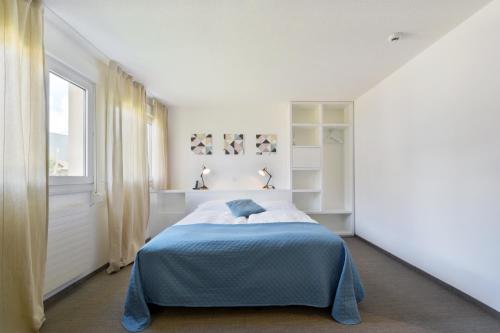 a bedroom with a bed and a window at Hôtel des Mosaiques in Orbe