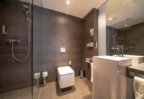 W łazience znajduje się toaleta, umywalka i prysznic. w obiekcie Q Hotel Grand Cru Gdańsk w Gdańsku