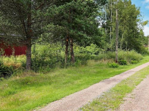 un camino de tierra junto a un campo con árboles en 4 person holiday home in RKELJUNGA, en Orkelljunga