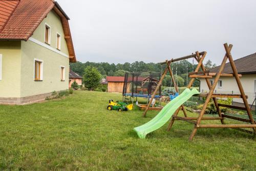 a yard with two swings and a slide at Rodinný apartmán Rodvínov in Rodvínov