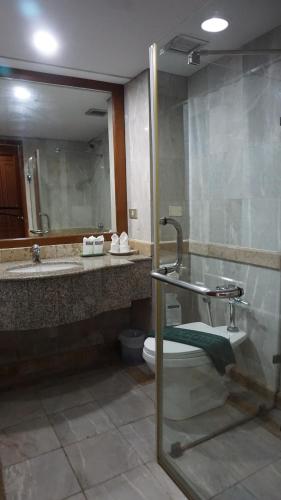 a bathroom with a sink and a toilet and a mirror at Wattana Park Hotel in Trang
