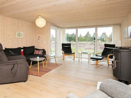 a living room with a couch and tables and chairs at 4 person holiday home in Thisted in Thisted