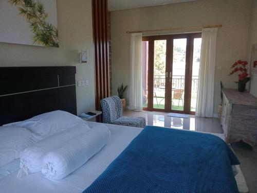 a bedroom with a large bed with a blue blanket at The Villa's Kubu Sandan in Kintamani
