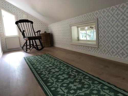 an empty room with a chair and a window at Sättraby villa in Norrtälje