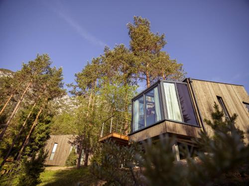 a house with glass windows on the side of it at Skyview Chalets am Camping Toblacher See in Dobbiaco
