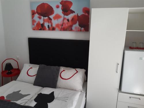 a bedroom with a bed with a black cat on it at Szalay Villa in Veszprém