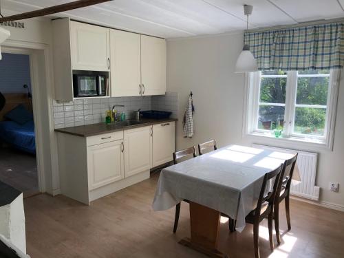 a kitchen and dining room with a table and chairs at Sättraby villa in Norrtälje