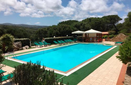 a swimming pool with blue water in a resort at La Liccia - Camping&Village in Santa Teresa Gallura