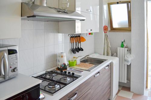 een keuken met een fornuis en een wastafel bij La Casa della Nonna Francesca in San Ferdinando di Puglia