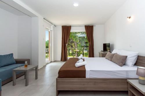 1 dormitorio con 1 cama grande y 1 sofá azul en Green Space Hotel, en Ohrid