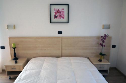 a bedroom with a white bed and two night stands at Villa Ombretta in Soraga