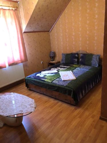 1 dormitorio con 1 cama grande y 1 mesa en Holiday en Perekrestʼye