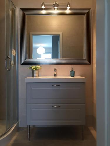 a bathroom with a sink and a mirror at Marcelin Apartments Poznań in Poznań