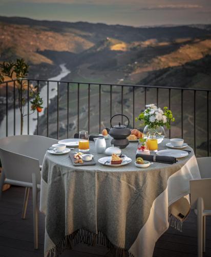 een tafel met eten en drinken op een balkon met uitzicht bij Encostas da Baronesa in Alijó