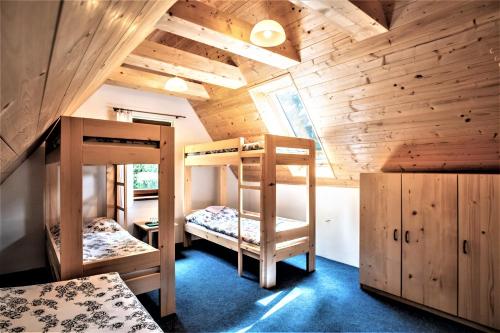 two bunk beds in a room with wooden walls at Ťatliakova chata in Zuberec