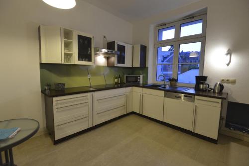 cocina con armarios blancos, mesa y ventana en Kaiserliche Hofpost, en Schleiden