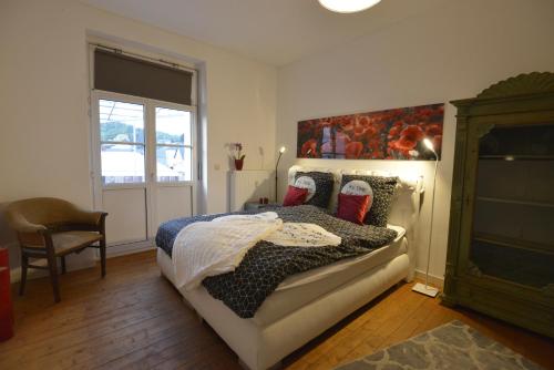 a bedroom with a bed and a chair and a window at Kaiserliche Hofpost, mit Whirlpool und 2 Terrassen in Schleiden
