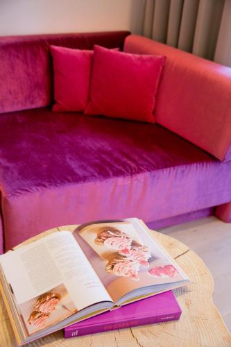 a book on a coffee table in front of a couch at Minglers Sportalm - Das Gourmet- und Genießerhotel in Kirchberg in Tirol