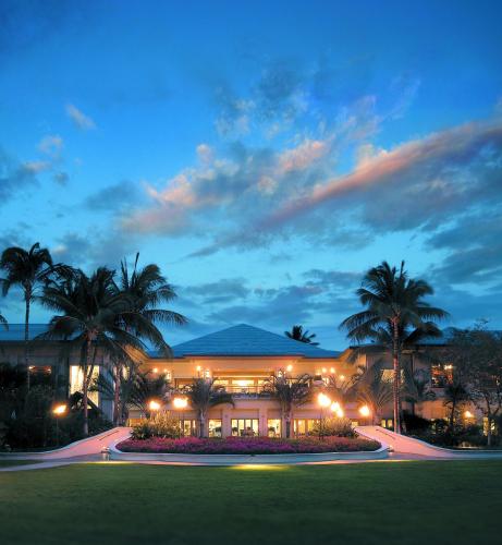 a large building with palm trees in front of it at Fairmont Orchid in Waikoloa
