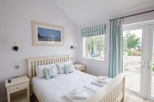 a white bedroom with a bed and a window at The Bay Filey in Filey