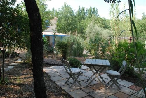 a picnic table and chairs in a garden at VILLA TERRE NEUVE in Signes