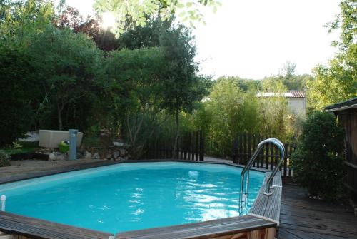 une grande piscine bleue avec une terrasse en bois dans l'établissement VILLA TERRE NEUVE, à Signes