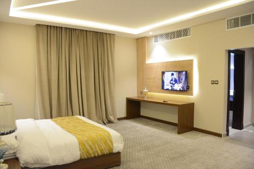 Habitación de hotel con cama y TV en E1 Hotel en Al Kharj