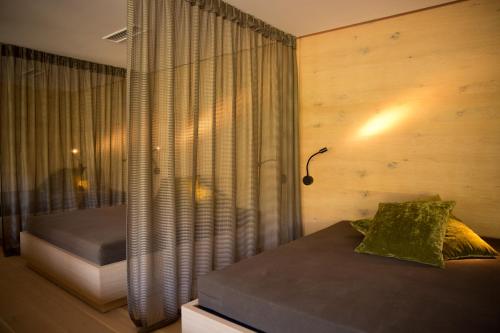 a bedroom with a bed and a window with a lamp at Minglers Sportalm - Das Gourmet- und Genießerhotel in Kirchberg in Tirol