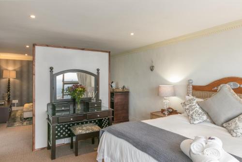 a bedroom with a bed and a vanity with a mirror at Villa Castollini in Brenton-on-Sea