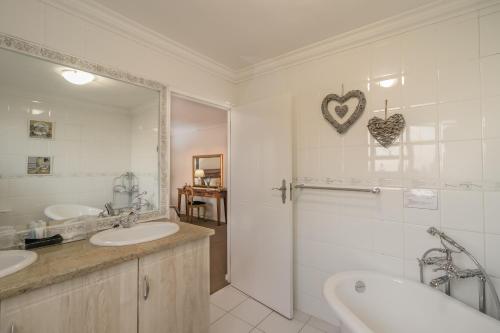 a bathroom with two sinks and a shower at Villa Castollini in Brenton-on-Sea