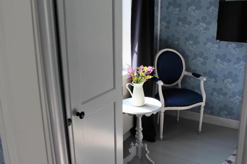 a vase of flowers on a table next to a chair at STF Hostel Vilhelmina Kyrkstad in Vilhelmina