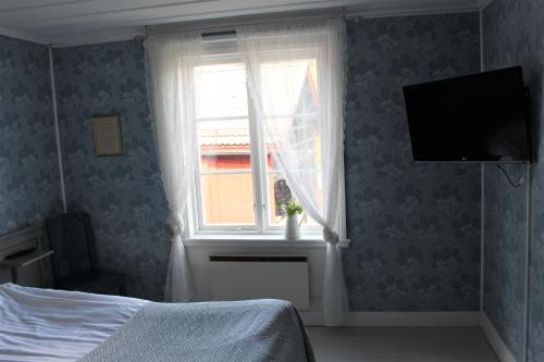 a bedroom with a window and a television on the wall at STF Hostel Vilhelmina Kyrkstad in Vilhelmina