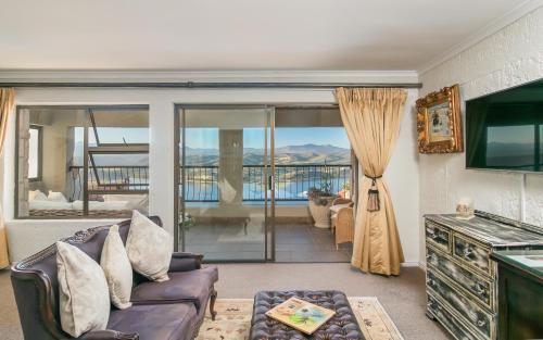 a living room with a couch and a tv at Villa Castollini in Brenton-on-Sea