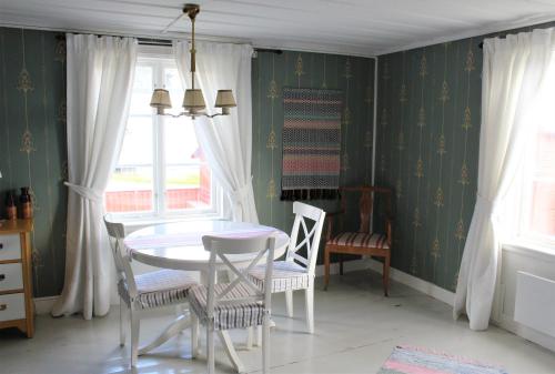 a dining room with a white table and chairs at STF Hostel Vilhelmina Kyrkstad in Vilhelmina