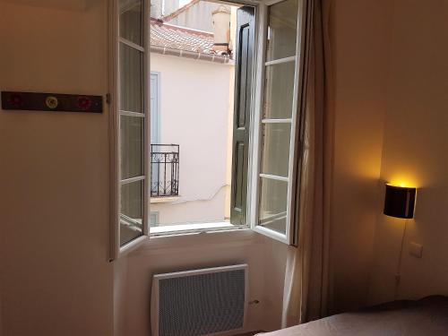 okno w pokoju z łóżkiem i łóżkiem sidx sidx sidx w obiekcie Appartement de charme à 50m de la plage de sable w mieście Collioure